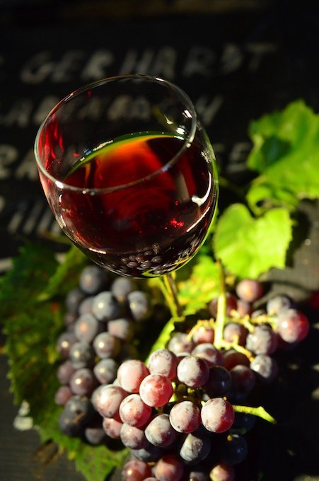 bicchiere di vino rosso e uva sotto il sole
